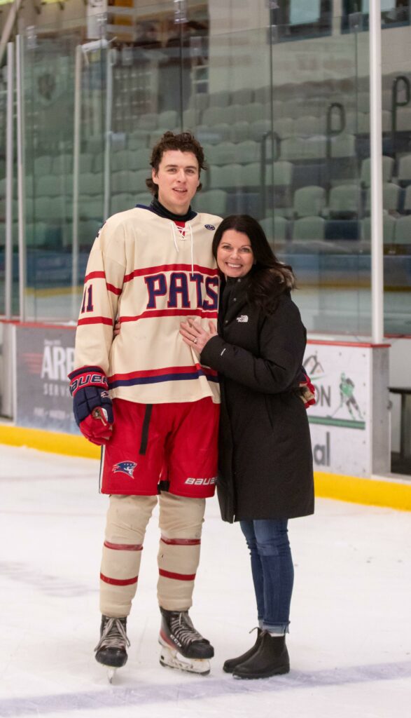 Nikki hugging her son who is in an ice hockey uniform on an ice hockey rink